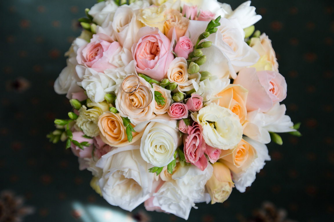 Wedding gold rings on a bouquet of flowers